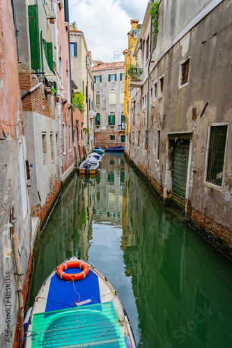 Obraz na płótnie Venice canal, a green water surrounded by buildings w salonie