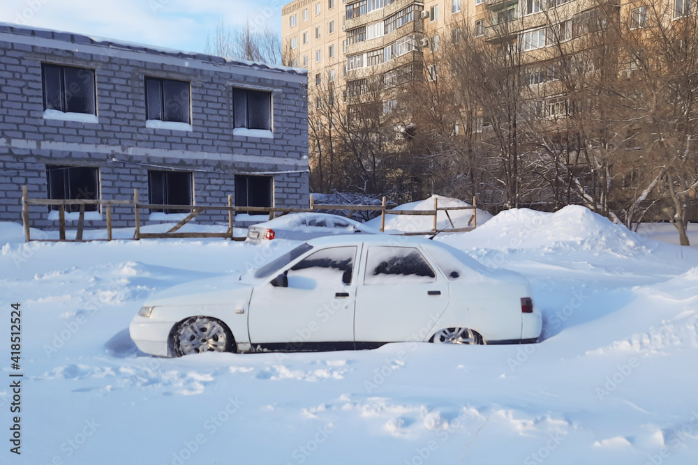 Snow covered white car with low ground clearance., Snow covered white car with low ground clearance.,