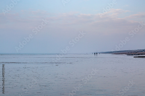 Distant Figures Walking on the Beach at Low Tide, at Shoreham-by-Sea
