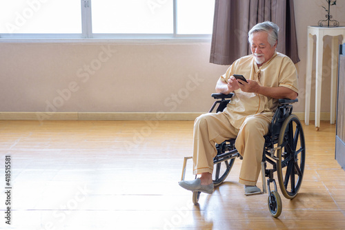 Photography .Elderly uncle sitting with a mobile phone Inside the hospital room, clinic.