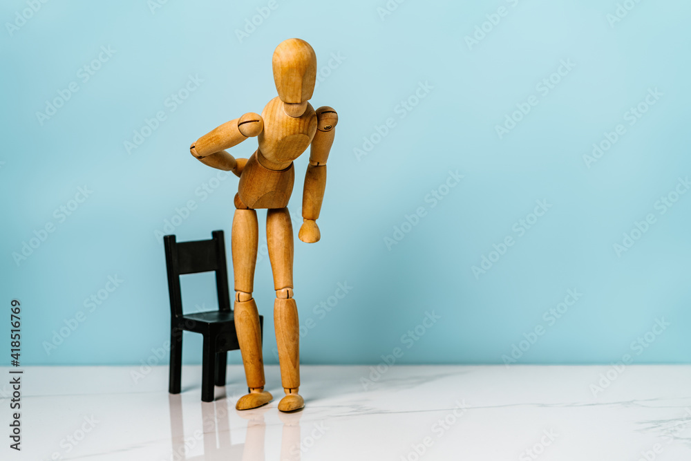 Concept of back pain. A wooden figure depicts a pain in the back.