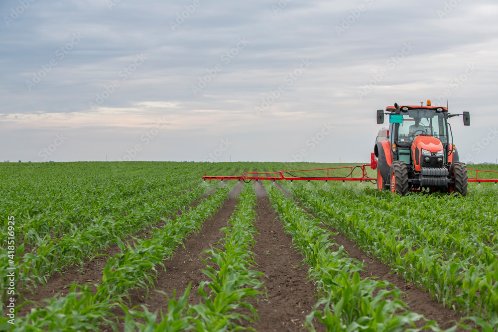 Tractor spraying pesticides at corn fields Tractor spraying pesticides at corn fields