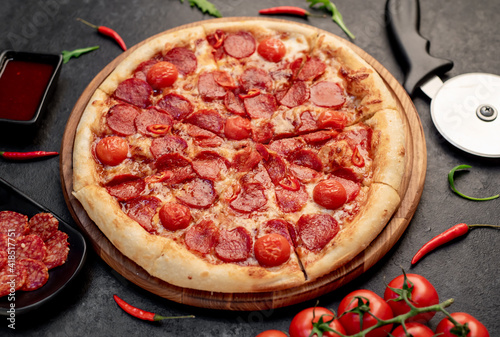 pepperoni pizza with ingredients on stone background