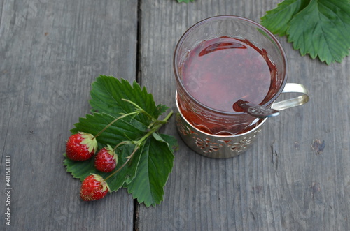 Berry strawberry tea and fresh garden strawberries on wooden background