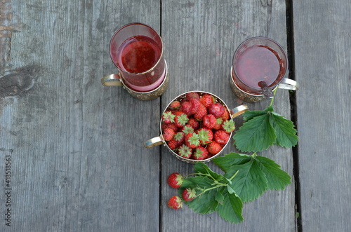 Berry strawberry tea and fresh garden strawberries on wooden background