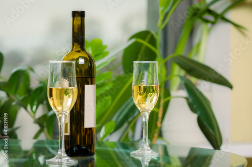 White wine bottle with two filled glasses