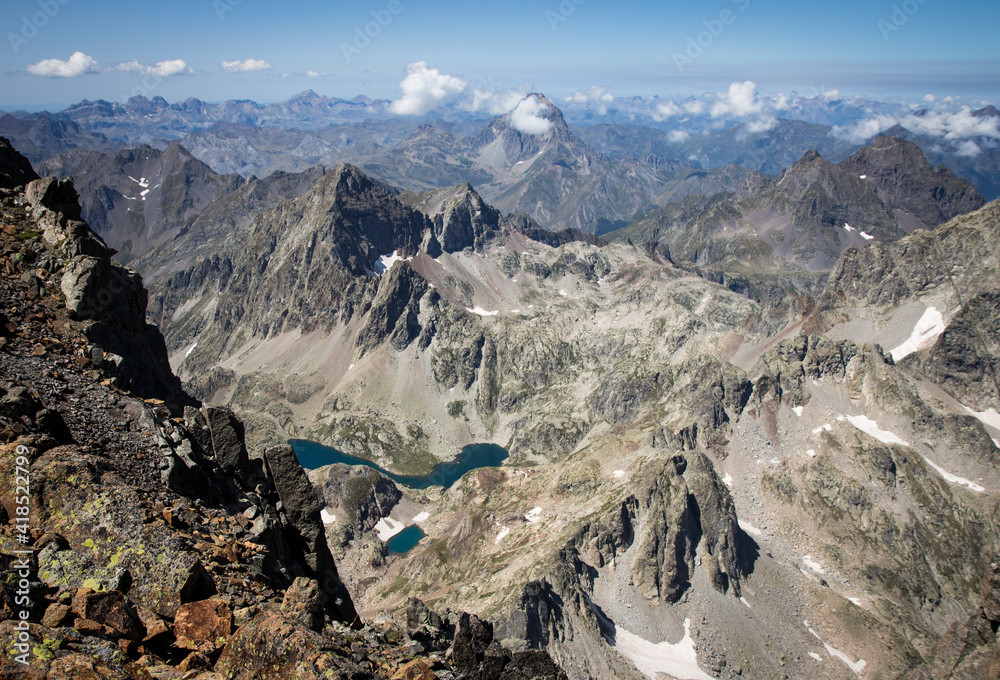 Spectacular view of the Pyrenees mountain range from the top of a mountain, with lakes below