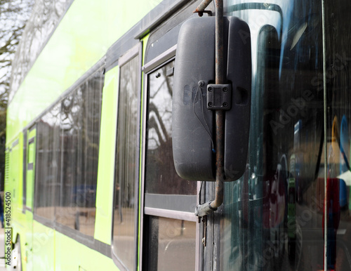 close outside rearview mirror of green double-decker sightseeing bus during the day photo