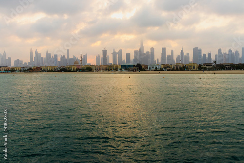 Dubai, UAE - 03.06.2021 Dubai public beach with city skyline on background.Sunrise hour. Outdoor © Four_Lakes