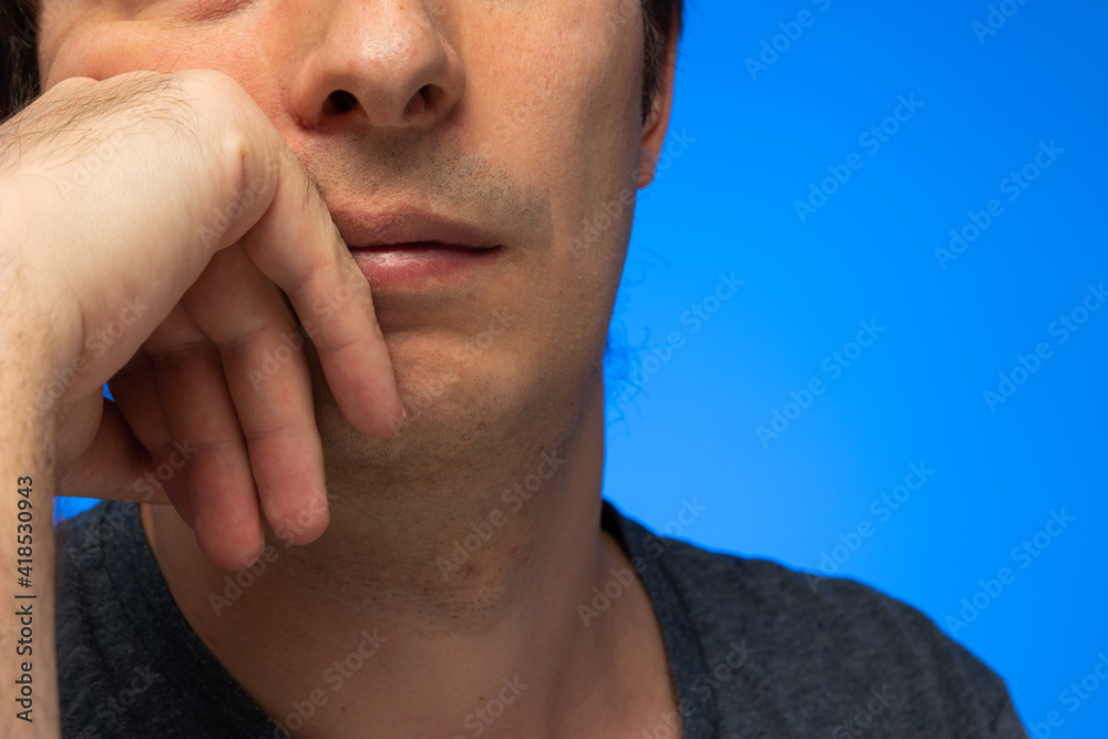 Fototapeta premium Caucasian male hand on face pensive worried look unrecognizable face crop close up studio shot