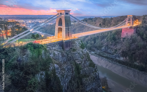 Cityscape view of Bristol, England, UK and the Clifton Suspension Bridge above the Avon Gorge and River Avon at sunset or sunrise from St Vincent's Rocks.