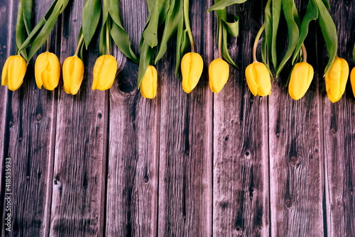 bouquet of yellow tulips on the background of an old gray wooden board, copy space. Valentine's Day, Woman's Day and Mother's Day concept.