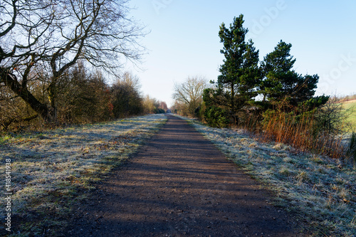 Early morning sun casts long shadows over a disused railway line photo