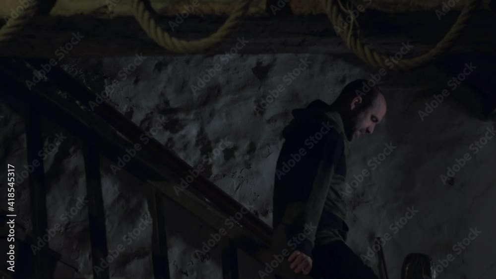 White caucasian man walking down old historic staircase. Moody scene White caucasian man walking down old historic staircase. Moody scene