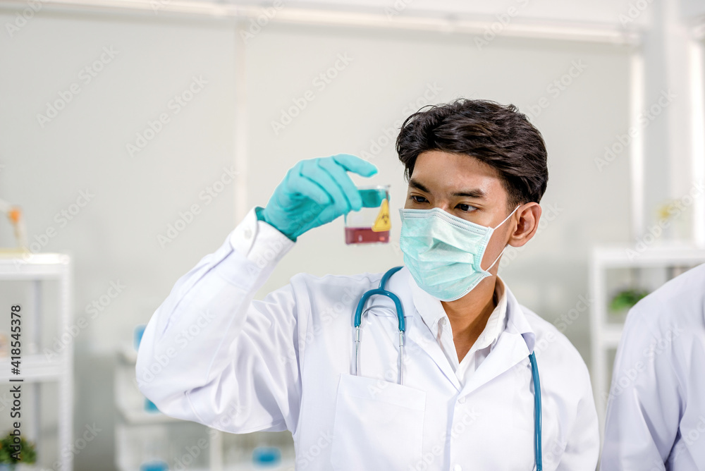 A scientist holding a beaker and looking at chemicals In it Inside the laboratory A scientist holding a beaker and looking at chemicals In it Inside the laboratory