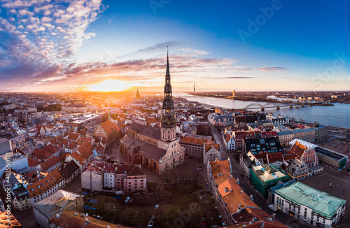 Aerial panoramic view to histirical center Riga, quay of river Daugava. Famous Landmark - st. Peter's Church's tower and City Dome Cathedral church, Old Town Monument. Latvia, Europe. shot from drone