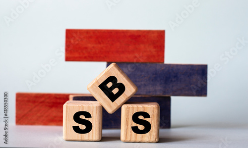 SBS - acronym on wooden cubes on a background of colored block on a light background photo