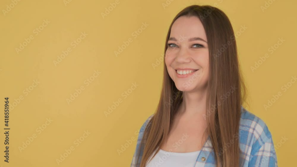 Portrait of a young dreaming woman on yellow background isolated. Woman nice looking and shy Portrait of a young dreaming woman on yellow background isolated. Woman nice looking and shy