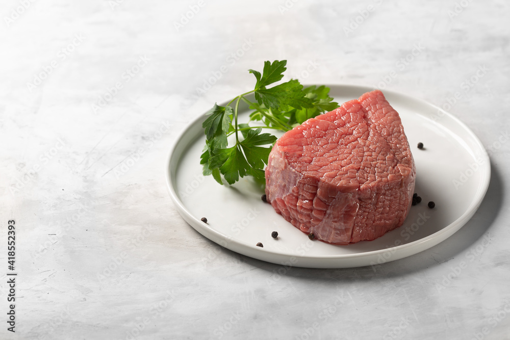 Fototapeta premium Fresh raw beef on white plate with copy space
