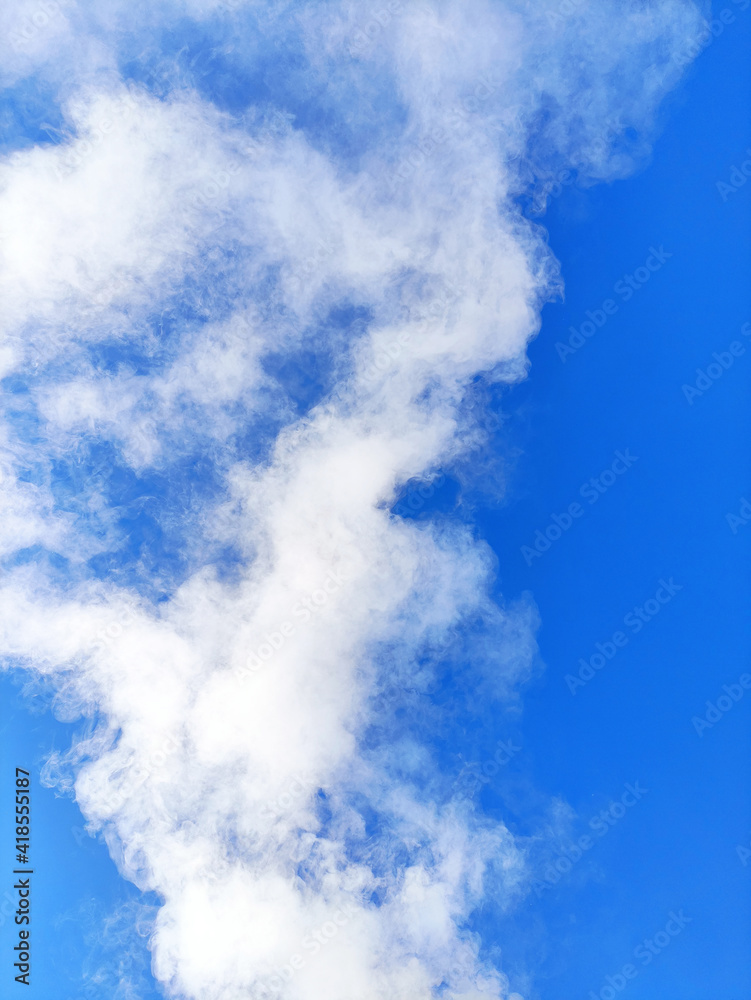 White smoke on the background of a bright blue sky on a winter frosty day