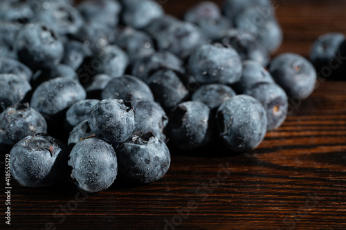 Blueberries in drops of water on a brown wooden table