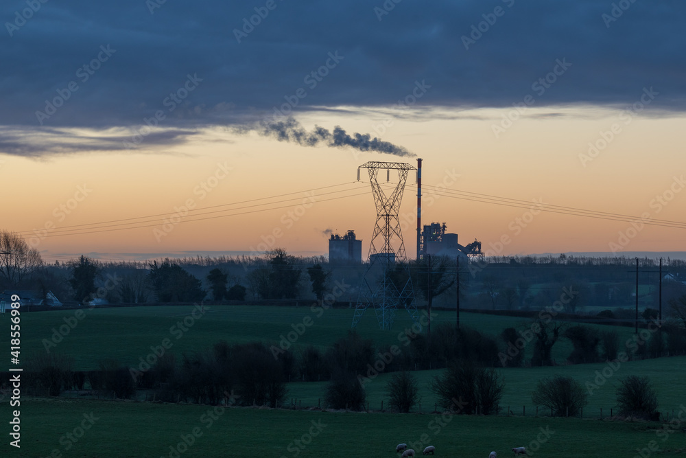 Early morning landscape with factory in the distance with sunrise sky at the background. Early morning landscape with factory in the distance with sunrise sky at the background.