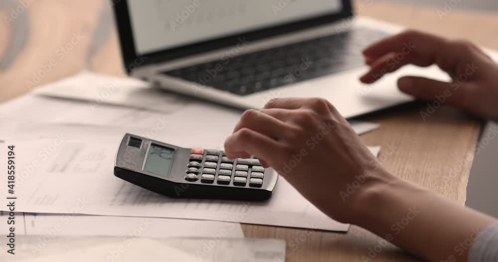 Close up young female ceo executive manager economist accountant analyzing project reports, planning financial budget using computer application, calculating expenditure and incomes at workplace.