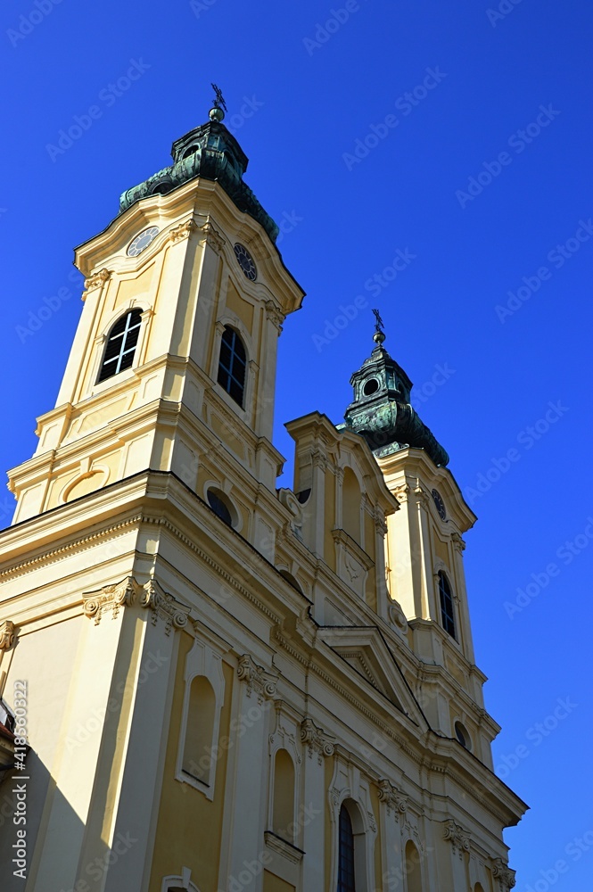 Baroque two-towered piarist church of St. Ladislav in Nitra, viewed from the street, spring clear blue skies. 