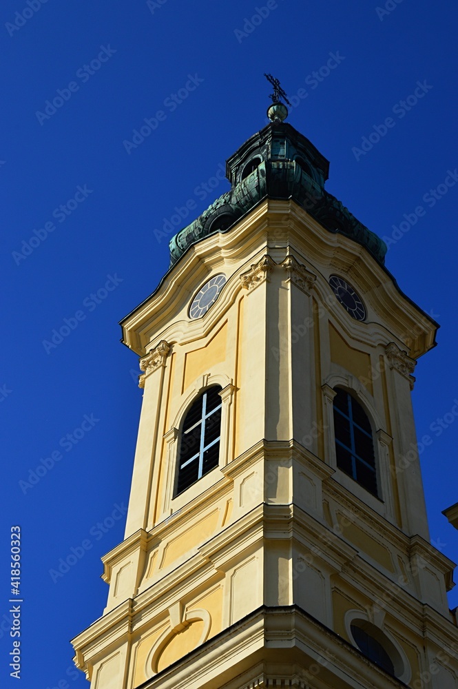 Left tower of two-towered baroque Piarist Church of St. Ladislav in Nitra, afternoon spring sunshine, clear blue skies. 