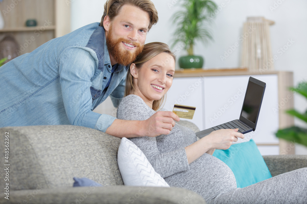 Fototapeta premium happy couple using laptop and credit card
