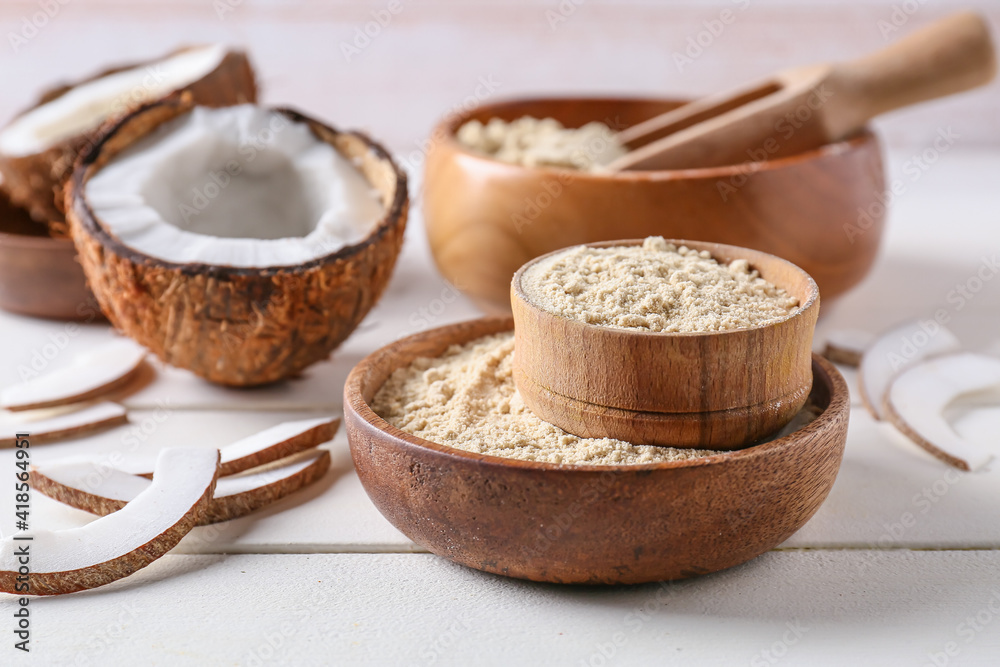 Bowls with coconut flour on light wooden background Bowls with coconut flour on light wooden background