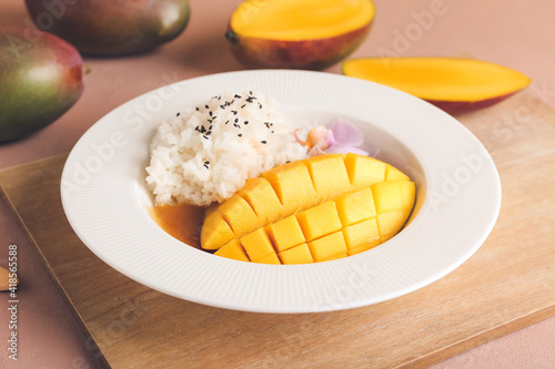 Fototapeta Naklejka Na Ścianę i Meble -  Plate with tasty rice and mango on color background