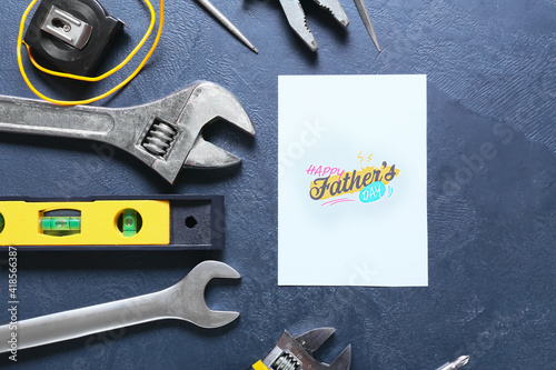 Composition for Father's Day with different tools and greeting card on color background