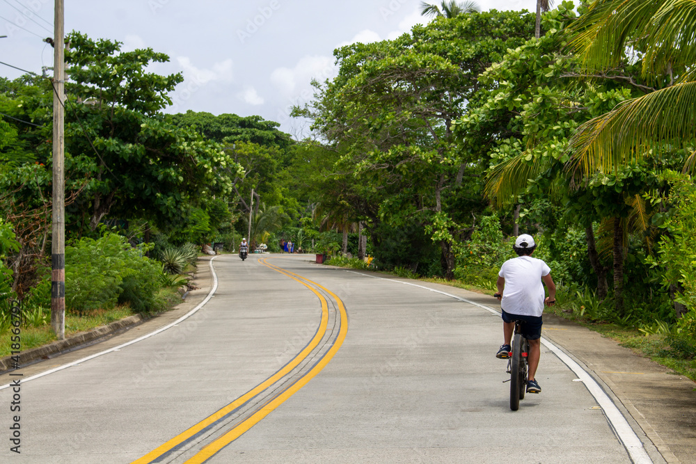 Fototapeta premium person riding a bike in a long way