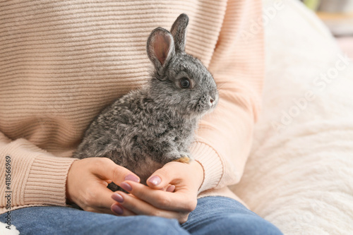 Young woman with cute rabbit at home