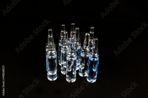 Ampoules with a solution on a black background.