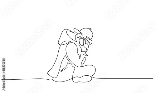 Young boy teenager sitting alone and talking by phone