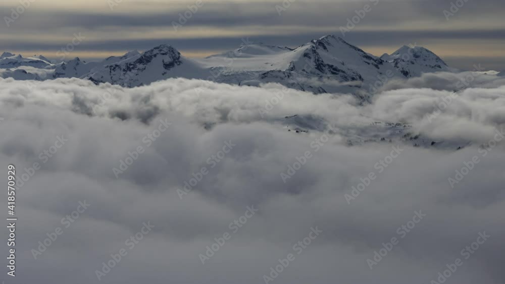 Beautiful Time Lapse View of Canadian Nature Mountain Landscape covered in Snow and clouds during winter. Taken on top of Blackcomb Mountain, Whistler, British Columbia, Canada. Nature Background. Beautiful Time Lapse View of Canadian Nature Mountain Landscape covered in Snow and clouds during winter. Taken on top of Blackcomb Mountain, Whistler, British Columbia, Canada. Nature Background.