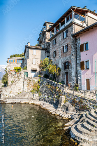 The village of Corenno Plinio with stone houses overlooking a small port © Alessio