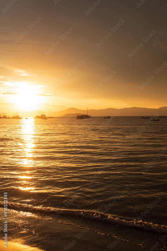 Sunset on a tropical beach with pirate boats in the background, located on the beach of Cachoeira do Bom Jesus, Canasvieras, Ponta das Canas, Florianopolis, Santa Catarina, Florianópolis, Brazil