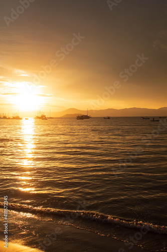 Sunset on a tropical beach with pirate boats in the background  located on the beach of Cachoeira do Bom Jesus  Canasvieras  Ponta das Canas  Florianopolis  Santa Catarina  Florian  polis  Brazil