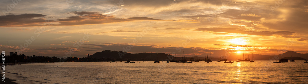 panoramic of the Sunset on a tropical beach with pirate boats in the background, located on the beach of Cachoeira do Bom Jesus, Canasvieras, Ponta das Canas, Florianópolis, Santa Catarina, Brazil