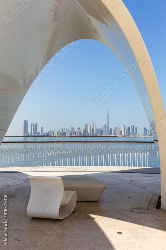 Photography Modern style chair with roof on a promenade overlooking Dubai Downtown with Burj Khalifa building and Dubai Creek, Dubai Creek Harbour, United Arab Emirates