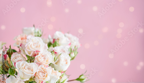 A bouquet of roses on a pink background with bokeh. Selective focus. Copy space
