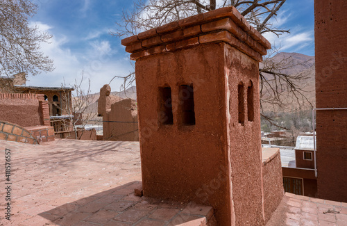 Streets of famous old Iranian village of Abyaneh. Barzrud Rural District, in the Central District of Natanz County, Isfahan Province, Iran. Red clay buildings. Mud bricks. photo