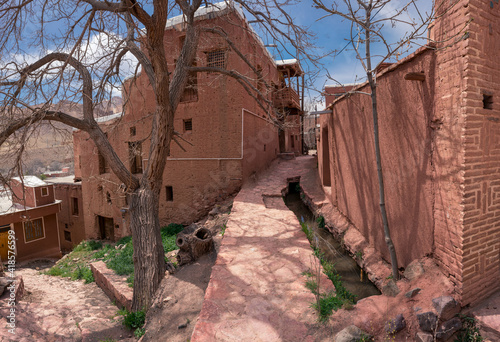 Streets of famous old Iranian village of Abyaneh. Barzrud Rural District, in the Central District of Natanz County, Isfahan Province, Iran. Red clay buildings. Mud bricks. photo