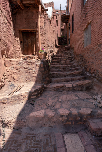 Streets of famous old Iranian village of Abyaneh. Barzrud Rural District, in the Central District of Natanz County, Isfahan Province, Iran. Red clay buildings. Mud bricks. photo