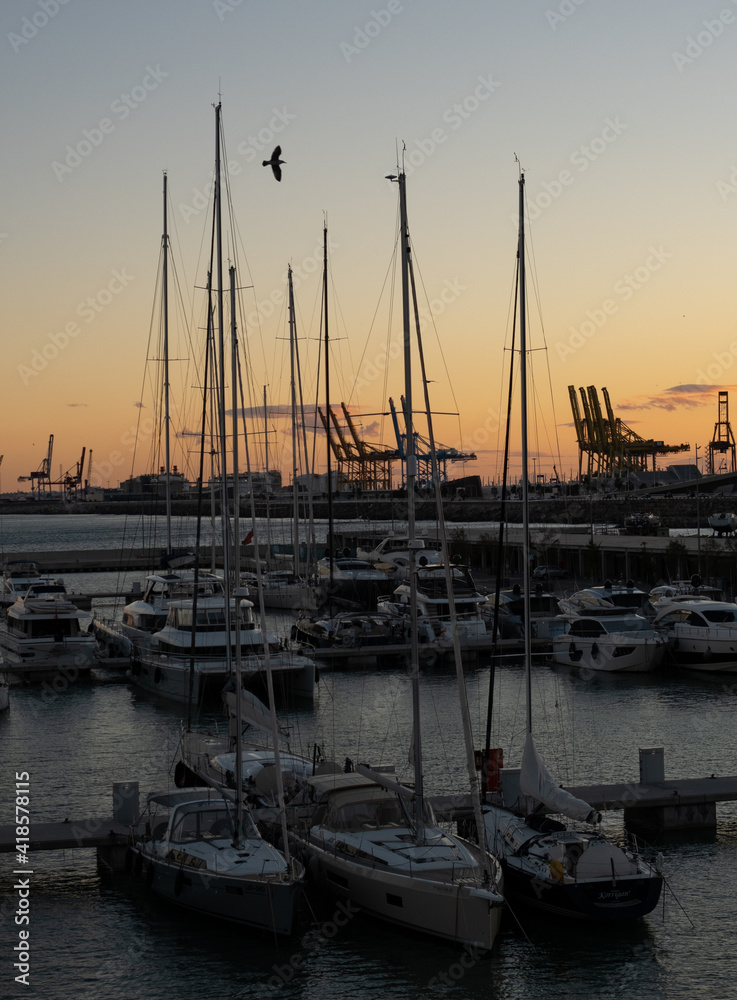 Port during the sunset. Sunset in the sea. Ships on the harbour. Harbor. Harbour. Boats on the port. Sunset harbor. Sunset harbour. European piere. Pieree. Summer port. Orange light. Ship mast. 