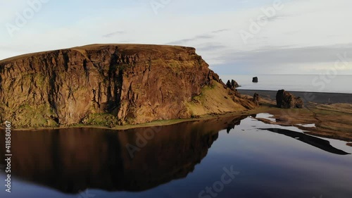 Dyrhólaey / Dyrholaey view point and its surrounding from an aerial drone 4k point of view, around the endless black sand beach during sunset, part1 