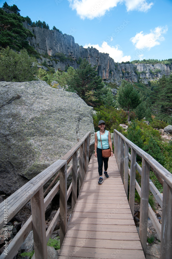 woman crossing a bridge in the mountain